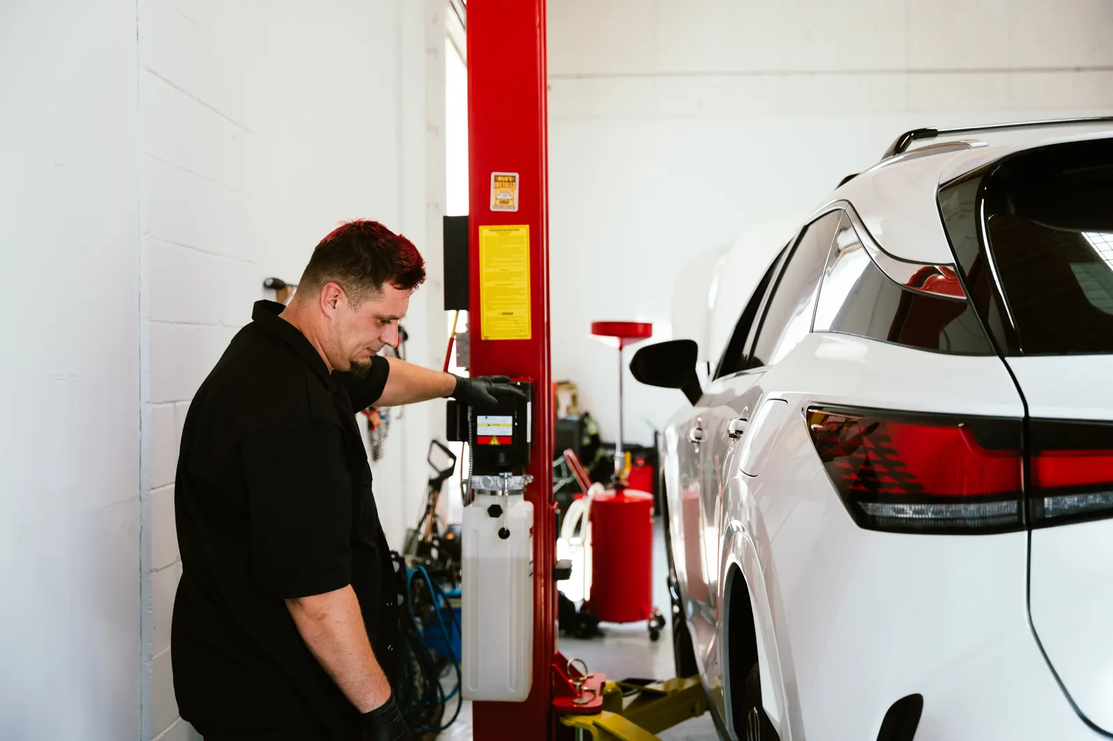 Technician inspecting a vehicle on a lift at Cali Car Care in Escondido, CA