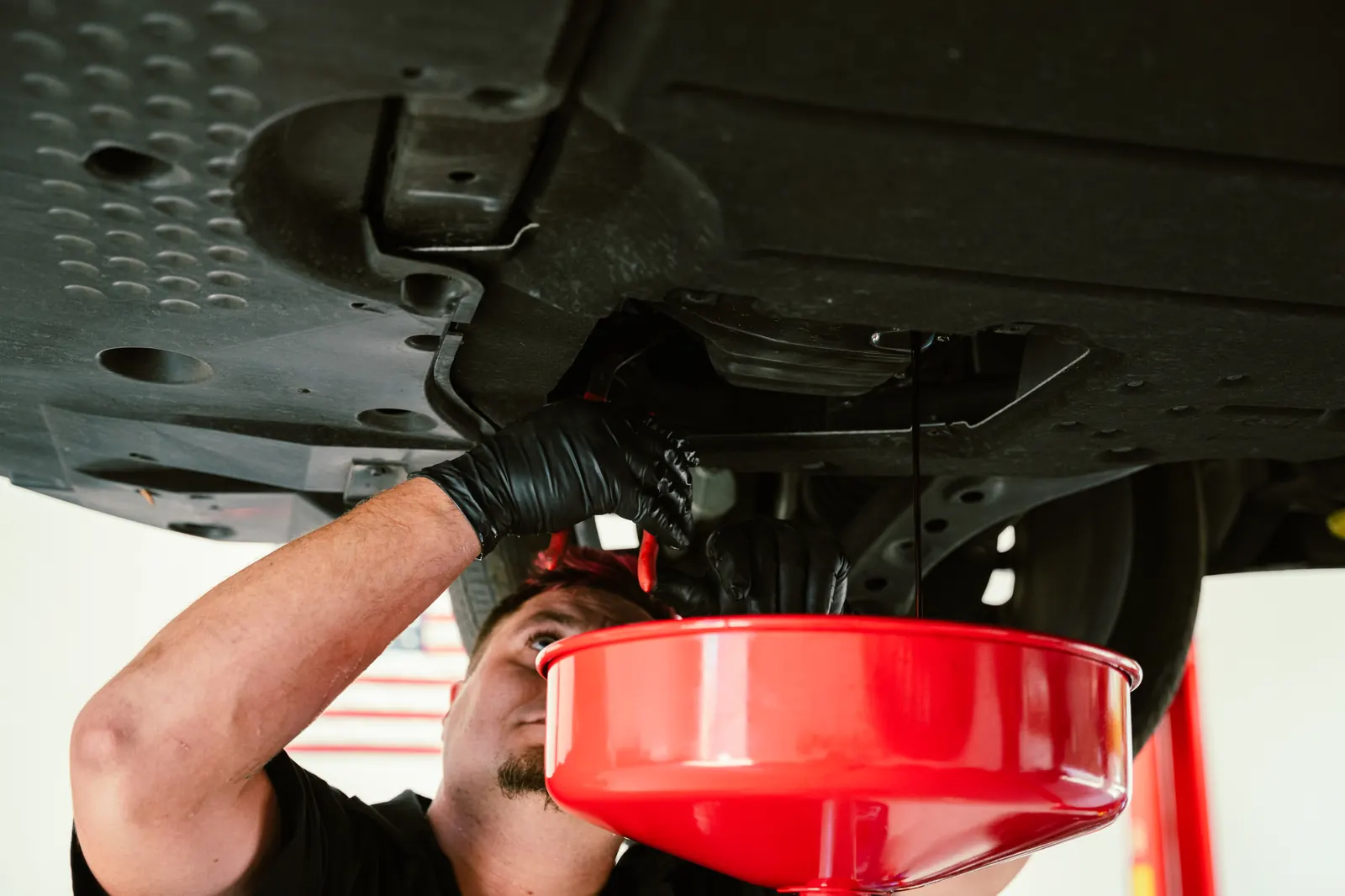 Mechanic pouring fresh oil into a car engine in Escondido, CA