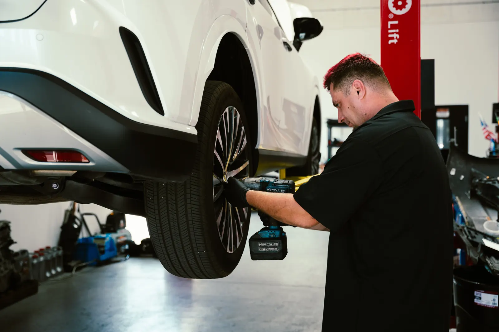 Mechanic using an impact wrench on a vehicle wheel in Escondido, CA